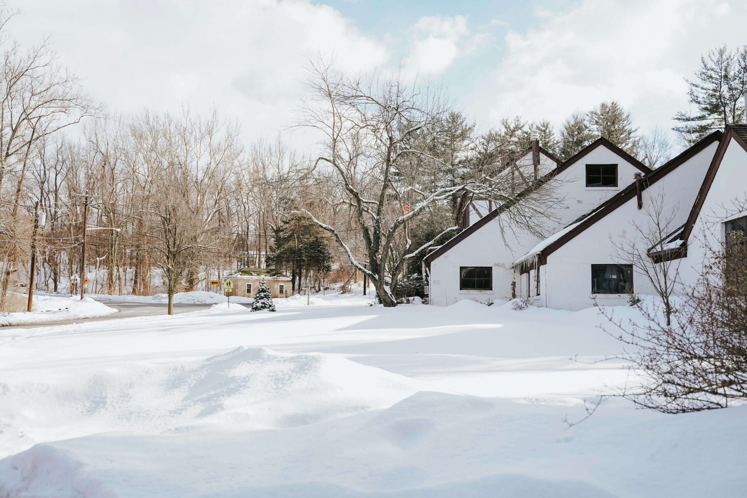 Winter scene showing a home in a snowy residential area.