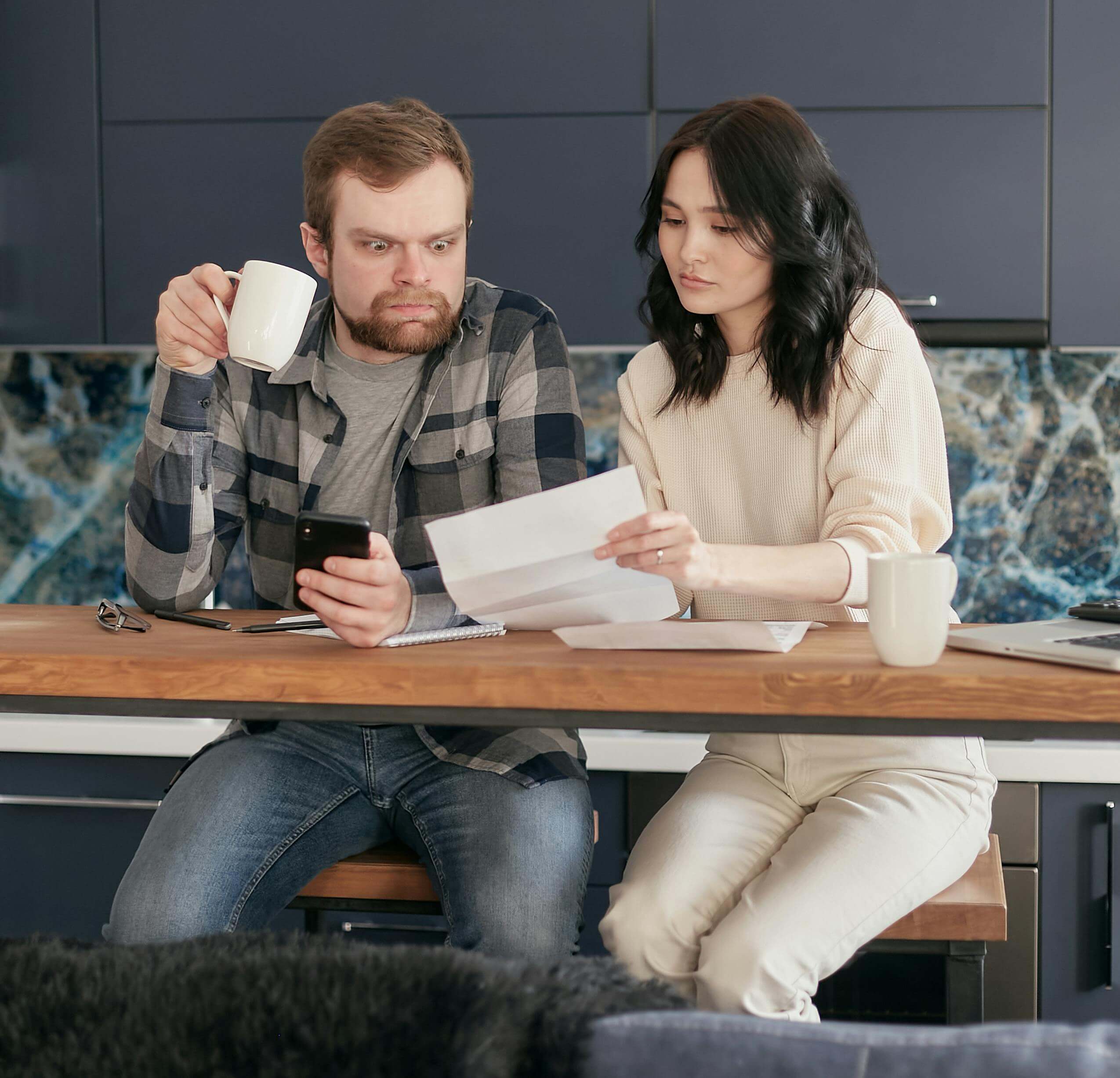 Husband shocked by energy bill his wife is showing him.